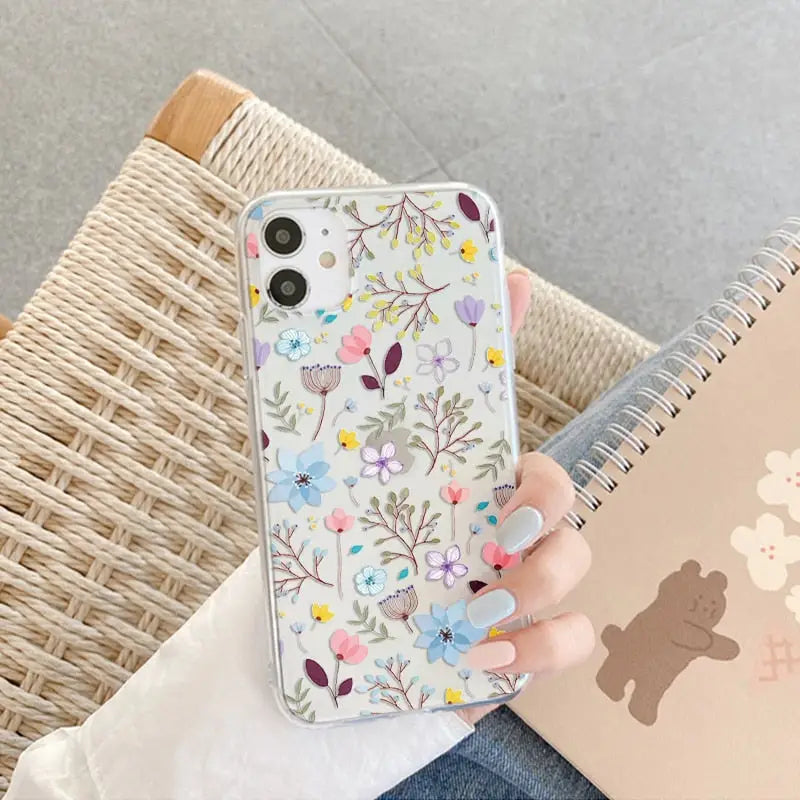 a woman holding a phone case with a flower pattern