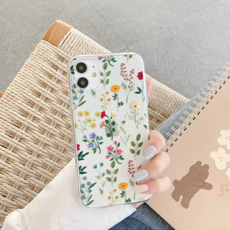 a woman holding a phone case with a flower pattern