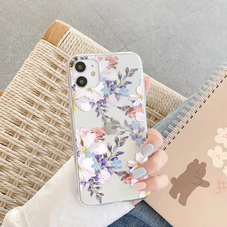 a woman holding a phone case with flowers on it