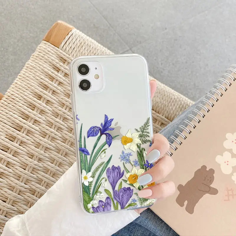 a woman holding a phone case with flowers on it