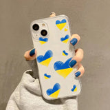 a woman holding a phone case with blue and yellow hearts on it