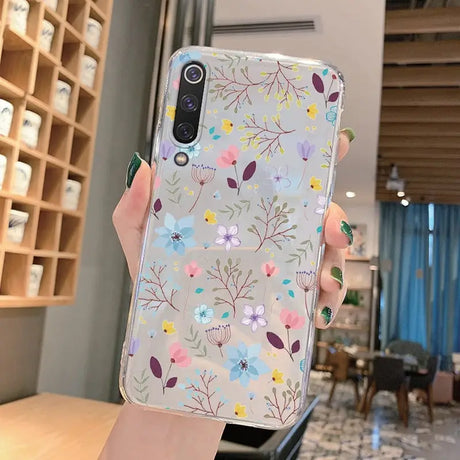 a woman holding a phone case with flowers on it