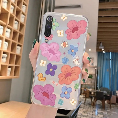 a woman holding a phone case with flowers on it