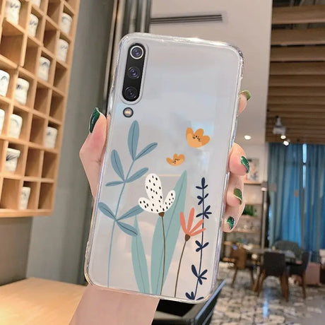 a woman holding a phone case with flowers on it