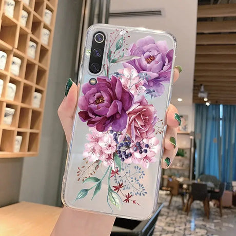 a woman holding a phone case with flowers on it