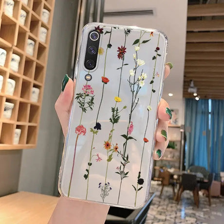 a woman holding a phone case with flowers on it