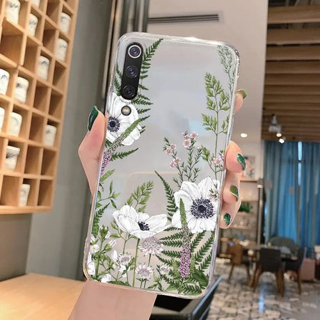 a woman holding a phone case with flowers on it