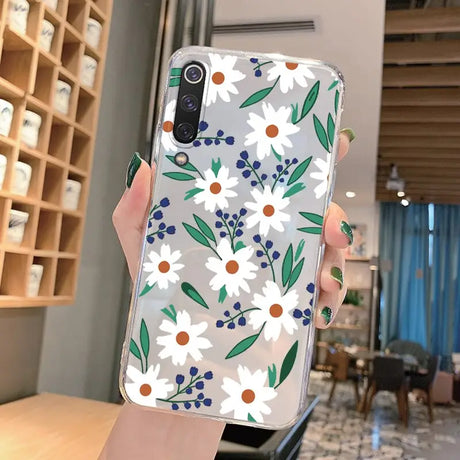 a woman holding a phone case with flowers on it