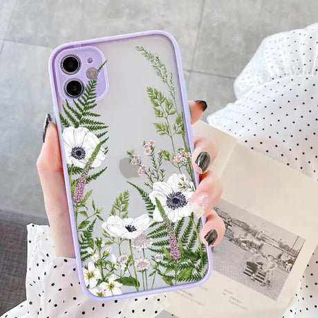 a woman holding a phone case with flowers on it