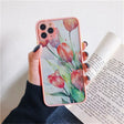 a woman holding a phone case with flowers on it