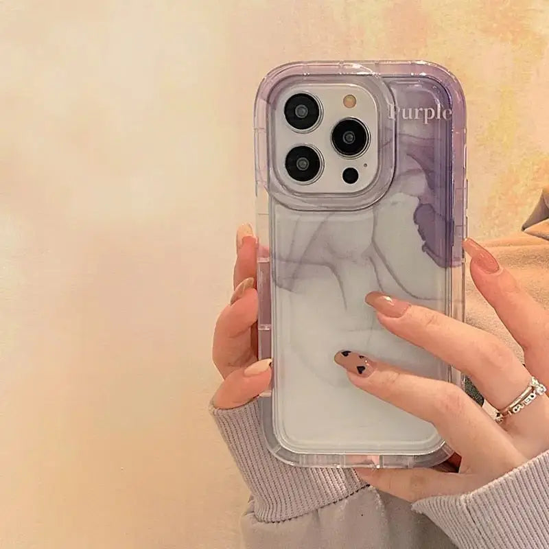 a woman holding a phone case with a purple and white marble pattern