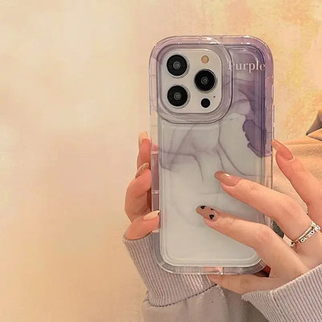 a woman holding a phone case with a purple and white marble pattern