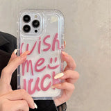 a woman holding a phone case with the words wish me