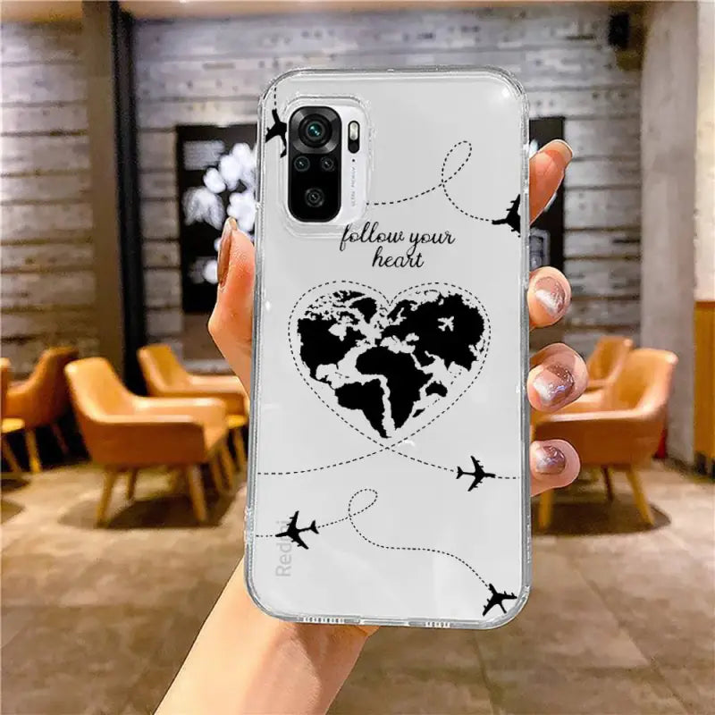 a woman holding up a phone case with a world map