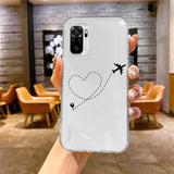 a woman holding up a white phone case with a heart drawn on it