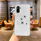 a woman holding up a phone case with a plane drawn on it