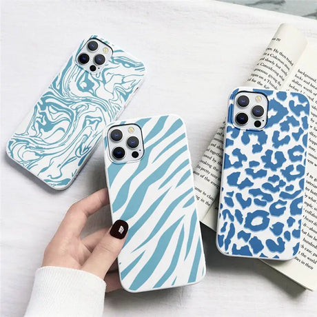 a woman holding a phone case with a blue and white animal print