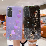 a woman holding two phone cases with heart charms