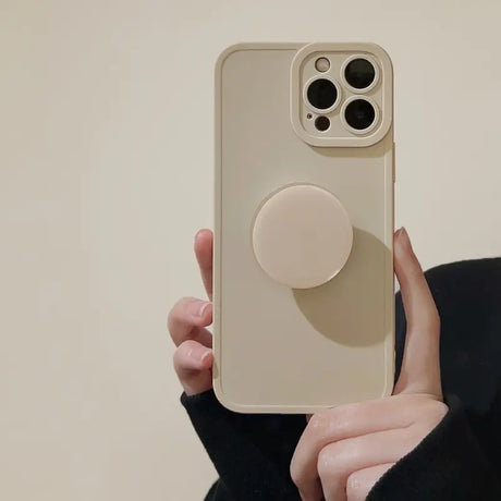 a woman holding a phone with a circular holder