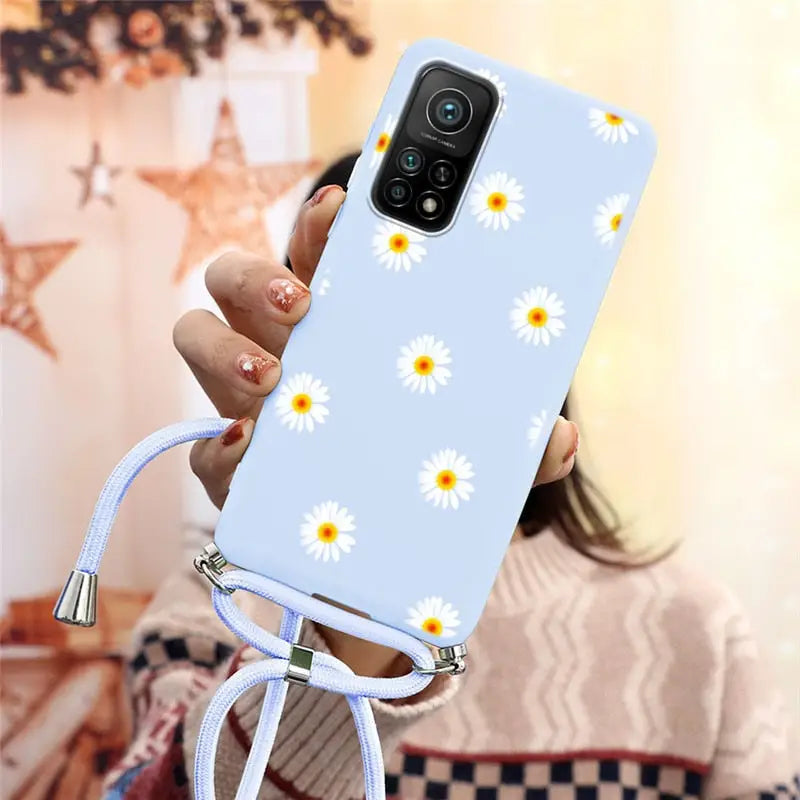 there is a woman holding a phone with a daisy pattern on it