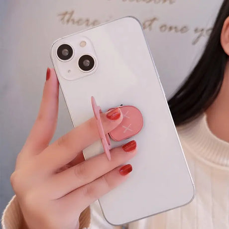 a woman holding a phone with a heart shaped sticker