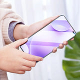 a woman holding a phone with a purple screen