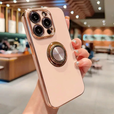 a woman holding a pink iphone case with a ring on it