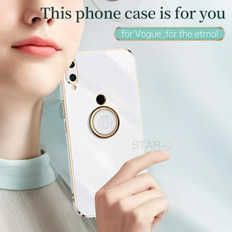 a woman holding a cell phone with a ring on it