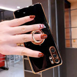 a woman holding a phone with a ring on it