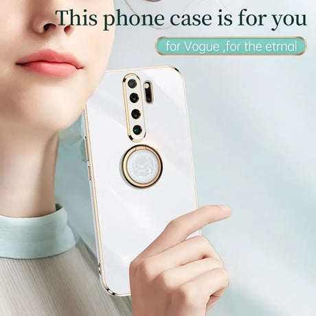 a woman holding a cell phone with a ring on it