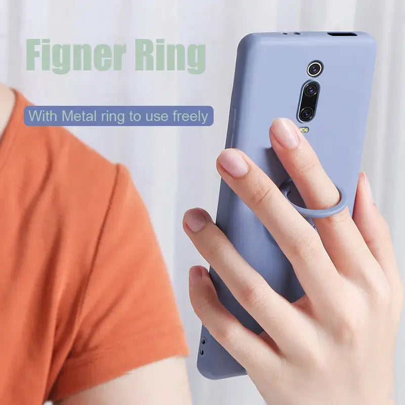 a woman holding a phone with the finger ring