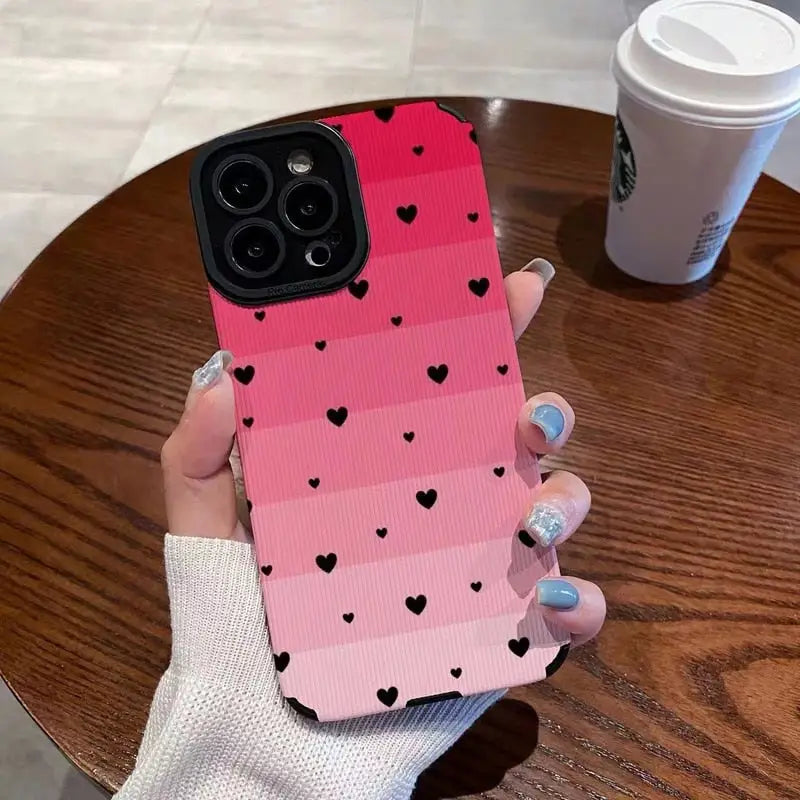a woman holding a pink and black phone case