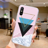 a woman holding a pink and black marble phone case