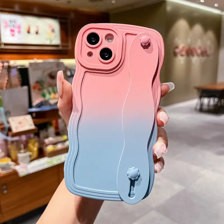 a woman holding a pink and blue phone case