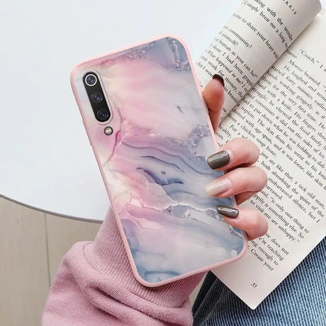 a woman holding a book and a phone case