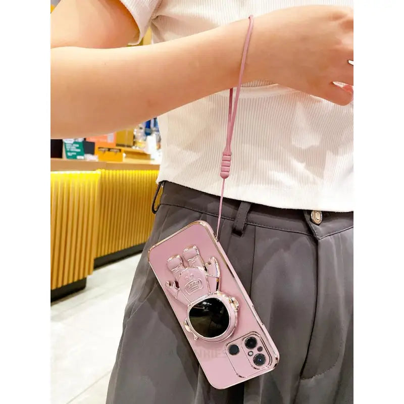 a woman holding a pink camera case
