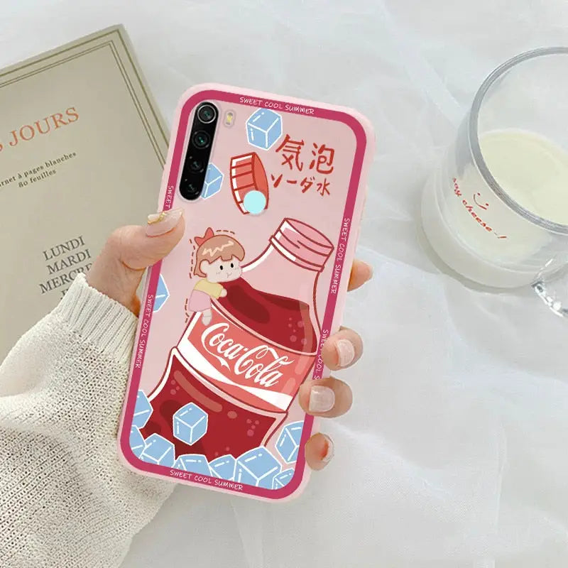 a woman holding a pink phone case with a coca cola