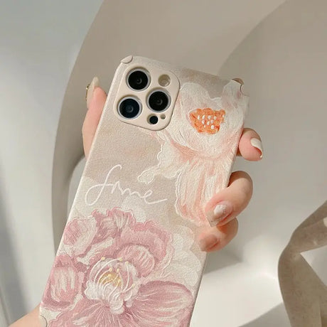 a woman holding a phone case with flowers on it