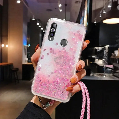 a woman holding a pink phone case with glitter