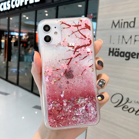 a woman holding a pink glitter phone case