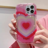 a woman holding a pink and white heart phone case