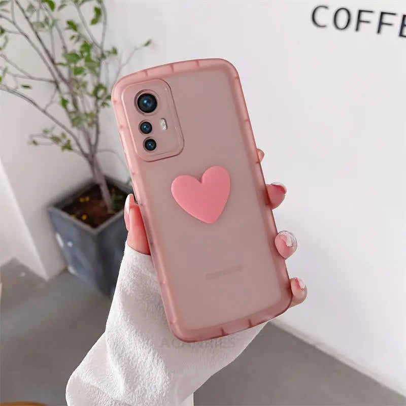 a woman holding a pink iphone case with a heart on it