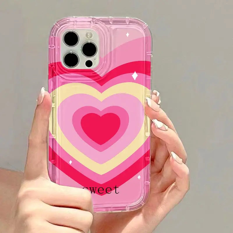 a woman holding a pink heart phone case