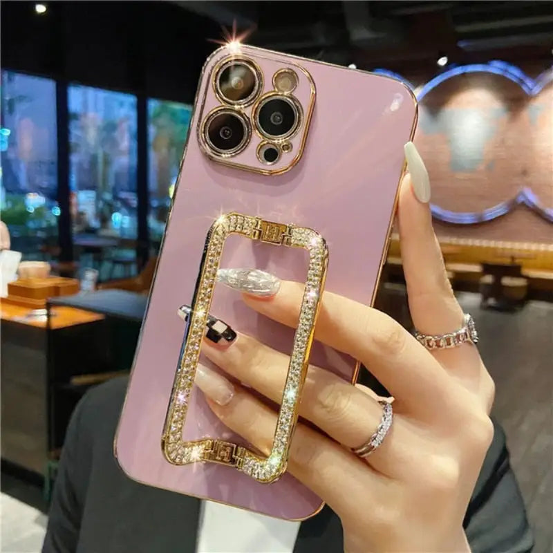 a woman holding a pink phone case with a ring on it