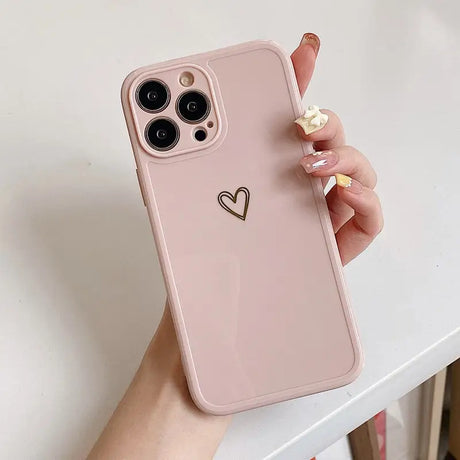 a woman holding a pink iphone case with a heart on it