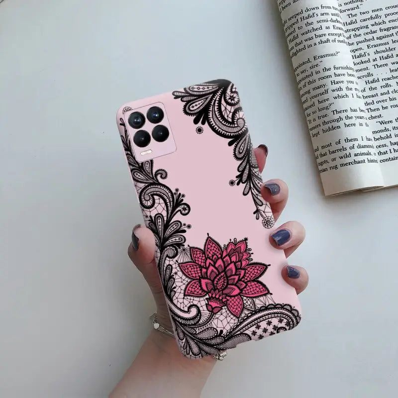 a woman holding a pink phone case with black and white floral design