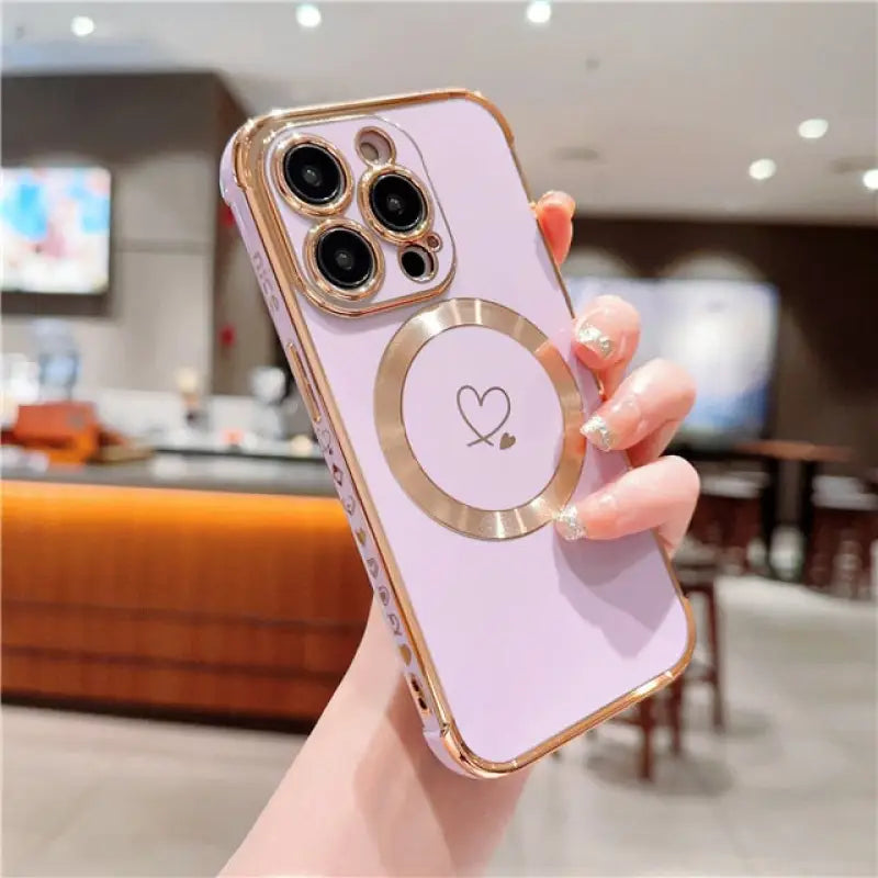 a woman holding a pink iphone case with a heart on it