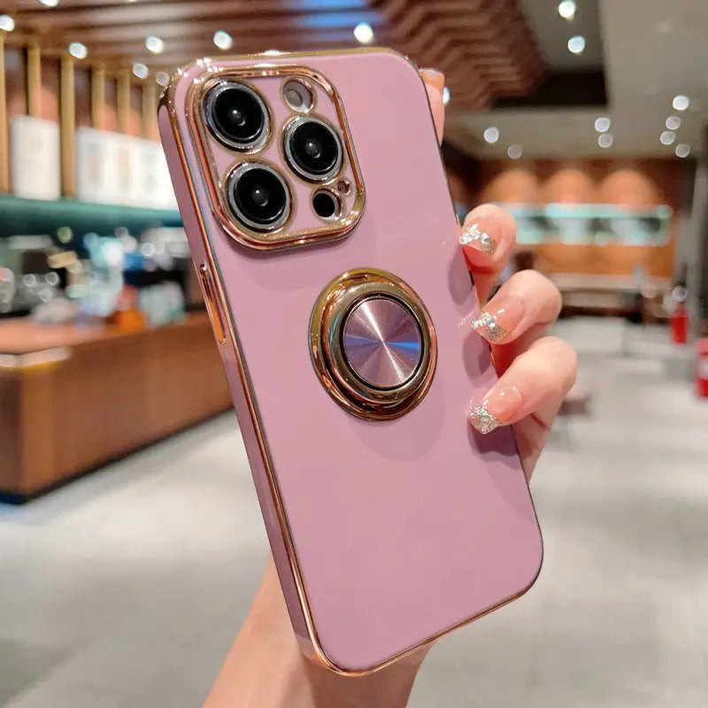 a woman holding a pink iphone case with a gold ring