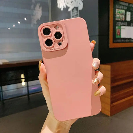 a woman holding up a pink iphone case