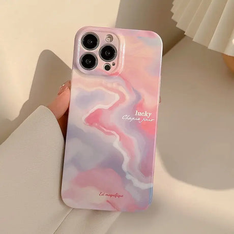 a woman holding a pink marble phone case